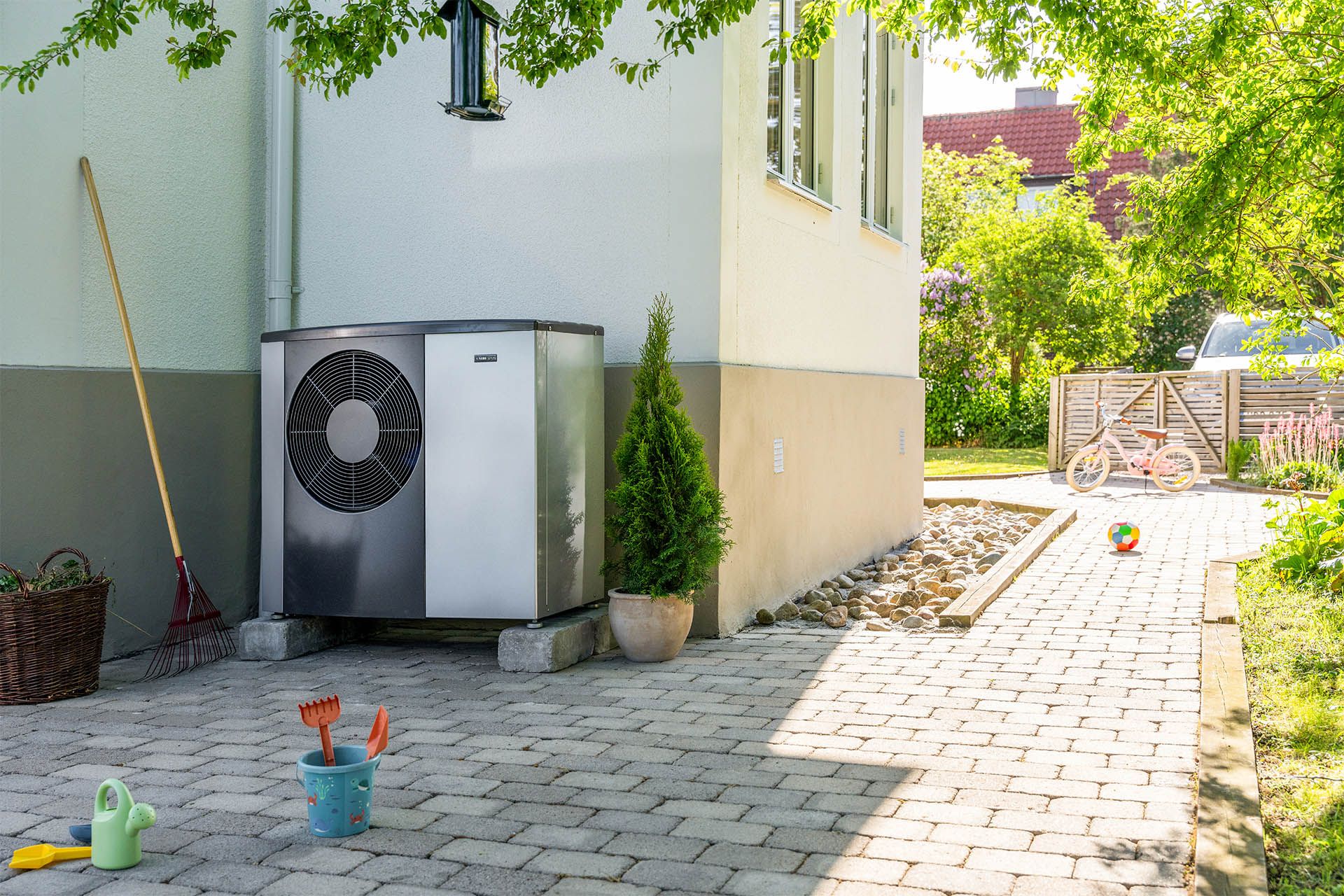 Außeneinheit einer Luft-Wasser-Wärmepumpe an einem sanierten Altbau